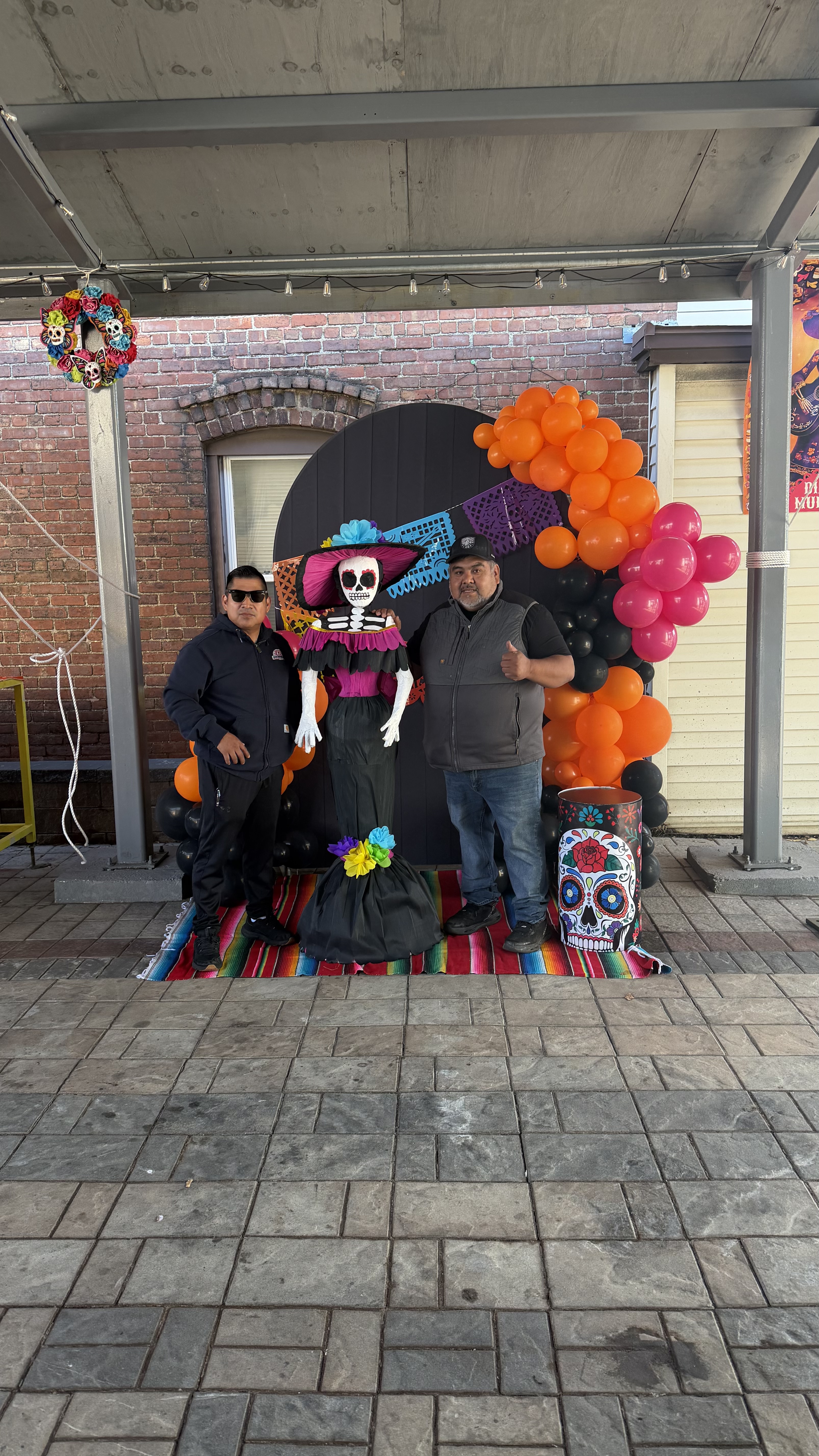 Community members posing with Catrina backdrop